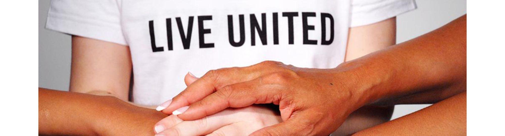 Live United volunteers with stacked hands